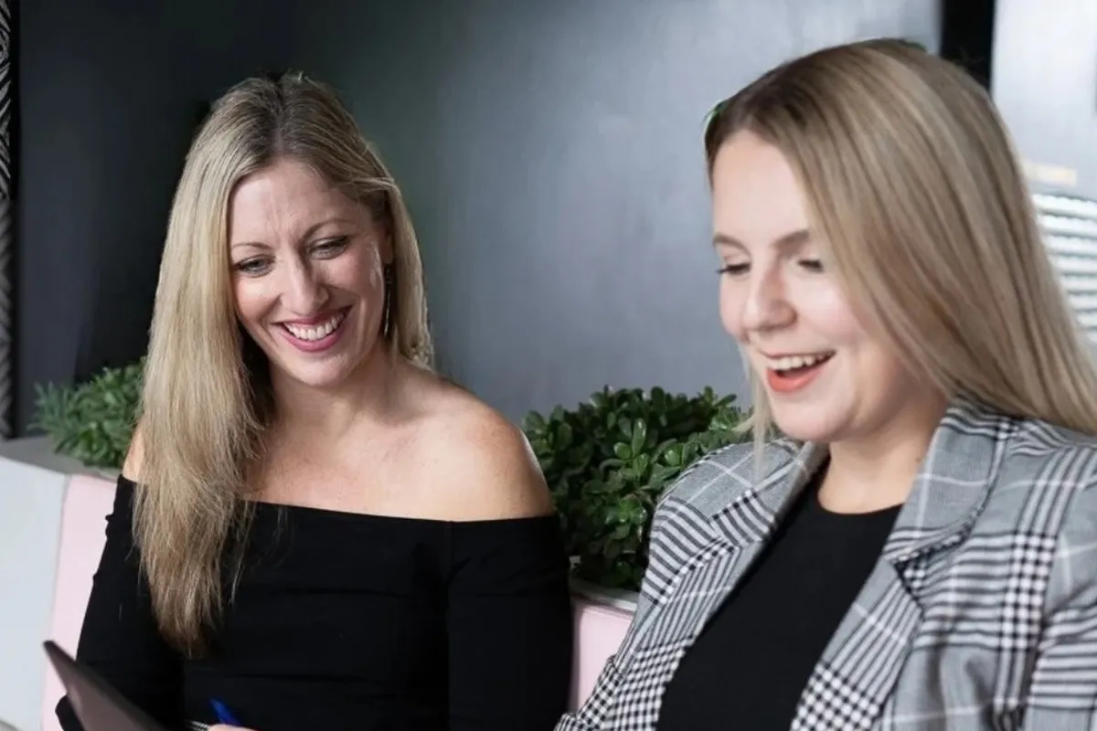 Kristy Hunter and a colleague reviewing a laptop together